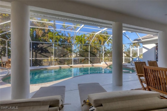 view of swimming pool with glass enclosure and a patio