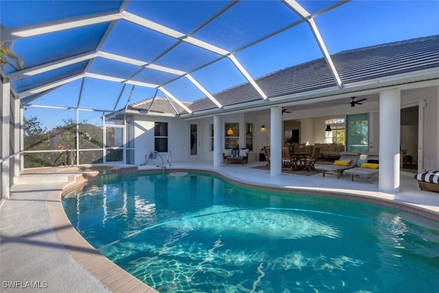 view of swimming pool with ceiling fan, a patio area, and glass enclosure