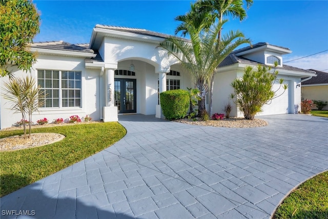 view of front of house with a garage, a front yard, and french doors