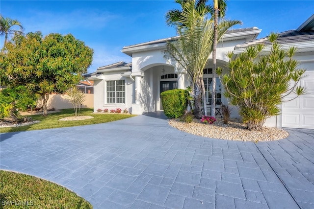 view of front of house with a garage and stucco siding