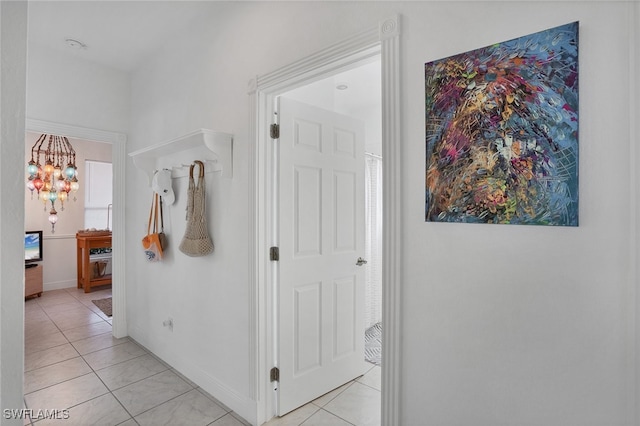 hall featuring a chandelier and light tile patterned flooring