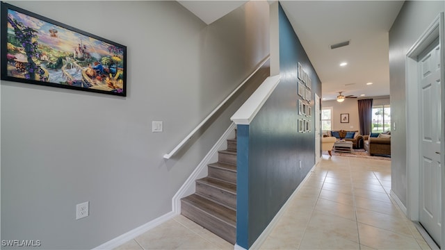 stairs with tile patterned floors and ceiling fan