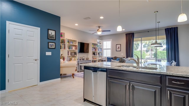 kitchen featuring ceiling fan, sink, hanging light fixtures, light stone counters, and stainless steel dishwasher