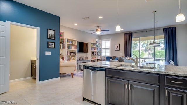 kitchen with light stone countertops, ceiling fan, sink, stainless steel dishwasher, and decorative light fixtures