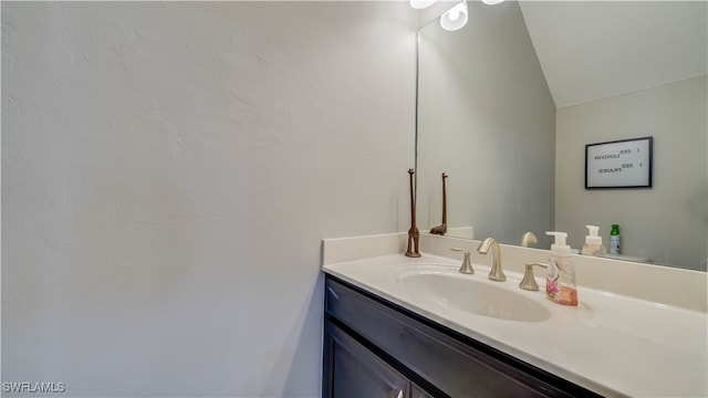 bathroom with vanity and vaulted ceiling