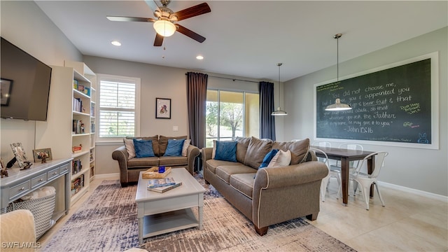 tiled living room with plenty of natural light and ceiling fan