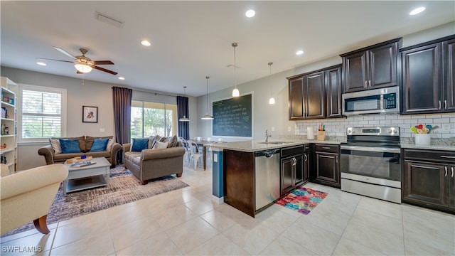 kitchen with kitchen peninsula, a healthy amount of sunlight, pendant lighting, and appliances with stainless steel finishes