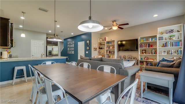 dining room featuring sink, ceiling fan, and light tile patterned flooring