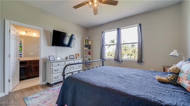 bedroom featuring ceiling fan, light hardwood / wood-style floors, sink, and ensuite bath