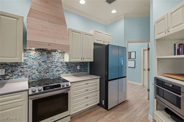 kitchen with light hardwood / wood-style flooring, ornamental molding, appliances with stainless steel finishes, tasteful backsplash, and extractor fan