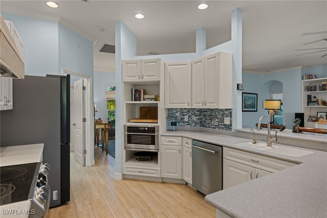 kitchen with white cabinets, stainless steel appliances, ceiling fan, and light hardwood / wood-style floors