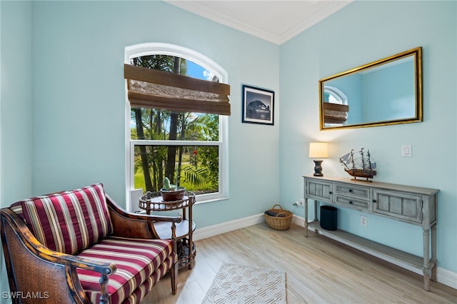 living area with light hardwood / wood-style floors and ornamental molding