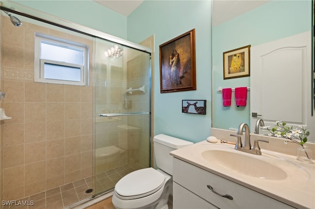 bathroom with vanity, toilet, and a shower with door