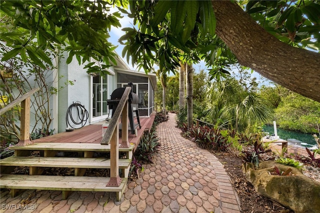 view of patio with a wooden deck and a sunroom