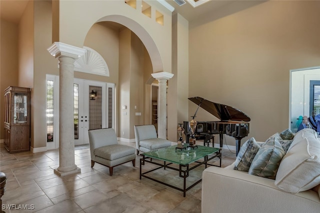 living room with a towering ceiling and decorative columns