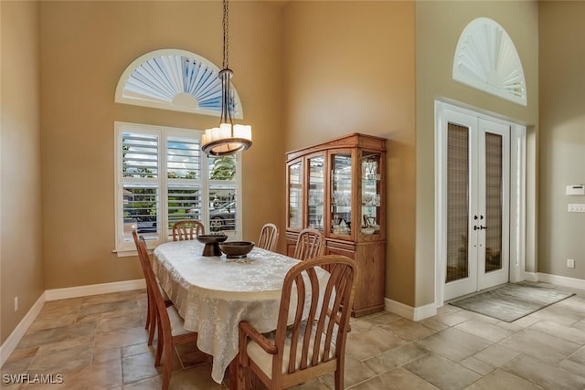 dining area featuring french doors and a high ceiling