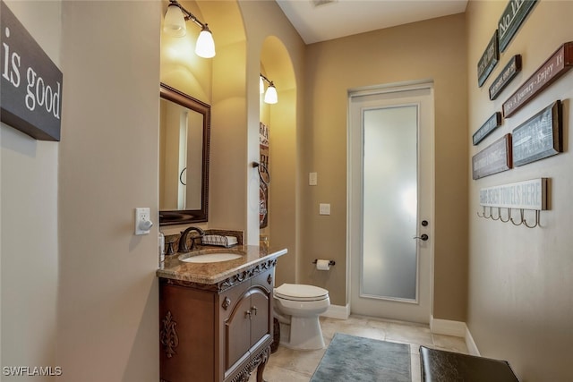 bathroom with tile patterned flooring, vanity, and toilet