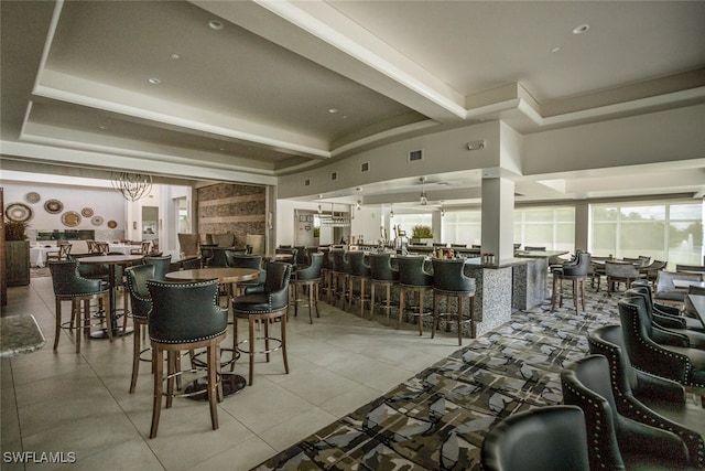 tiled dining area featuring a raised ceiling and beam ceiling