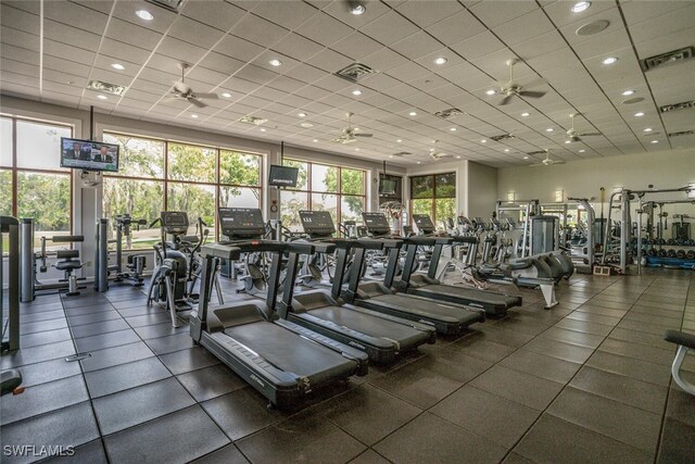 gym featuring ceiling fan and a drop ceiling