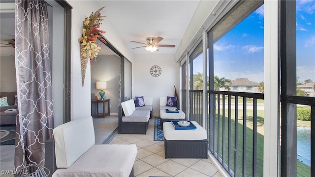 sunroom with a water view, a wealth of natural light, and ceiling fan