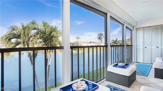 sunroom featuring a water view