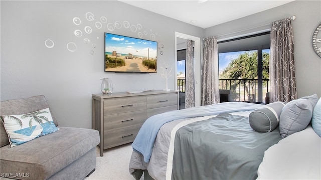 bedroom featuring access to exterior and light carpet