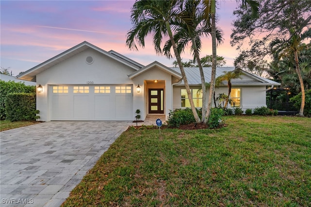 view of front of home with a lawn and a garage