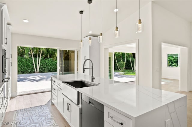 kitchen with a center island with sink, white cabinetry, and plenty of natural light