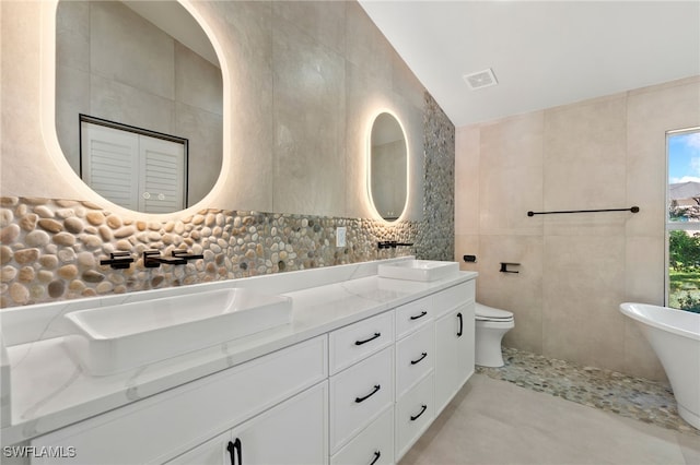 bathroom with decorative backsplash, vanity, tile walls, and toilet