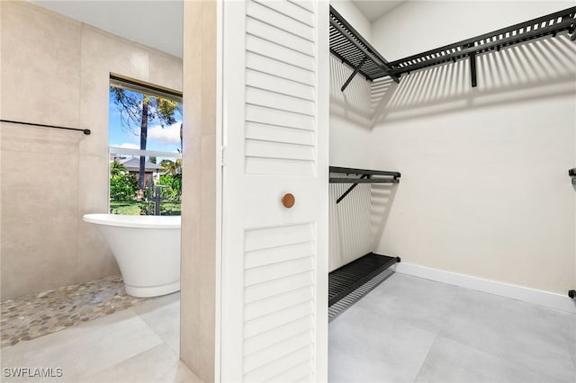 bathroom with concrete flooring and a tub to relax in