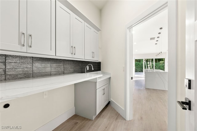 laundry room with light hardwood / wood-style flooring and sink