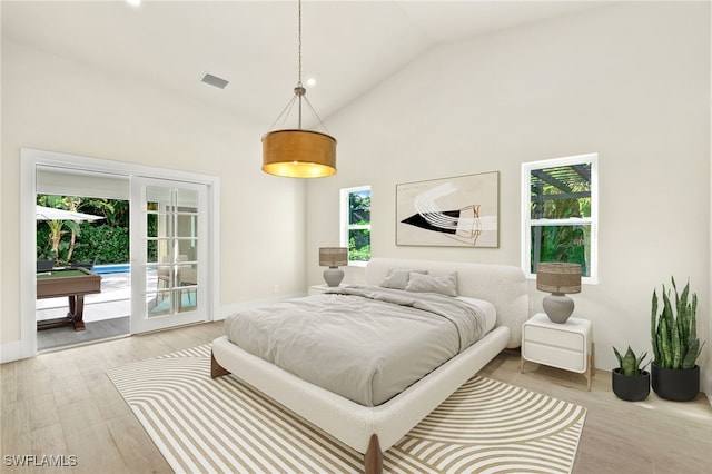 bedroom with access to exterior, french doors, high vaulted ceiling, light hardwood / wood-style flooring, and billiards