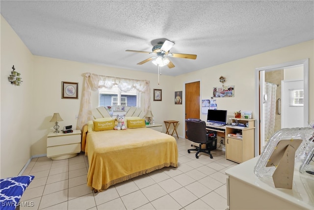 tiled bedroom featuring ceiling fan and a textured ceiling