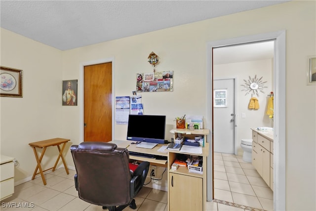 home office featuring light tile patterned floors and a textured ceiling