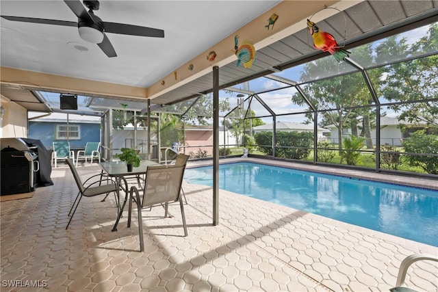 view of swimming pool with a patio, ceiling fan, a lanai, and a grill