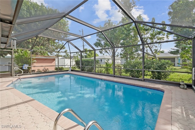 view of swimming pool featuring glass enclosure