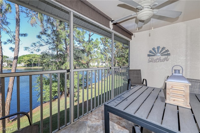 sunroom / solarium featuring ceiling fan and a water view