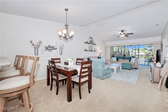 carpeted dining area with lofted ceiling and ceiling fan with notable chandelier