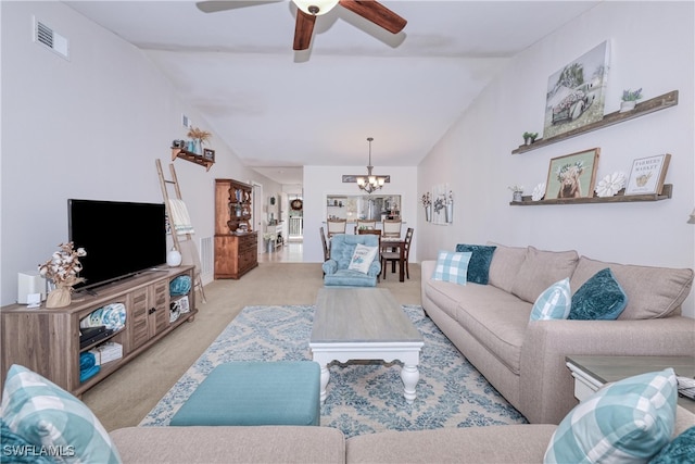 living room with ceiling fan with notable chandelier, vaulted ceiling, and light colored carpet