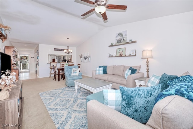 living room with lofted ceiling, ceiling fan with notable chandelier, and light colored carpet