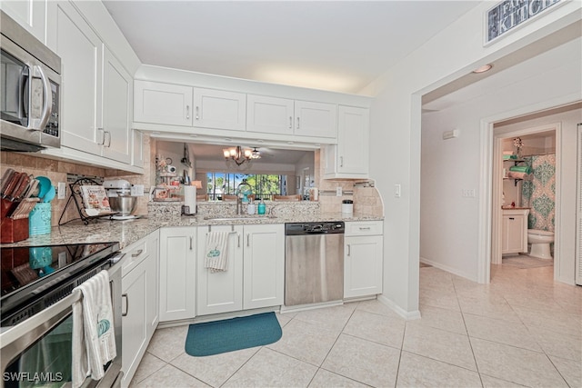 1140 Sarah Jean Cir Unit C-205, Naples, FL 34110 - kitchen with a sink, light tile patterned flooring, white cabinetry, decorative backsplash, and appliances with stainless steel finishes