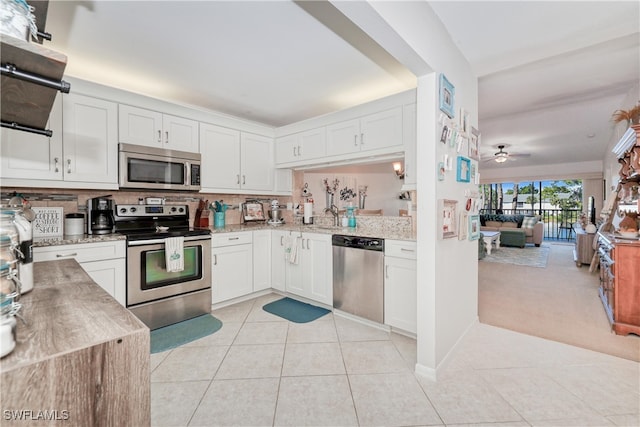 1140 Sarah Jean Cir Unit C-205, Naples, FL 34110 - kitchen with light tile patterned floors, ceiling fan, white cabinetry, tasteful backsplash, and appliances with stainless steel finishes