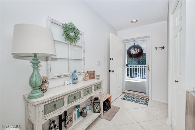 doorway featuring light tile patterned floors, baseboards, and recessed lighting