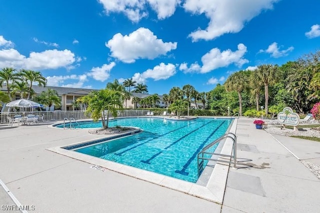 pool with a patio and fence