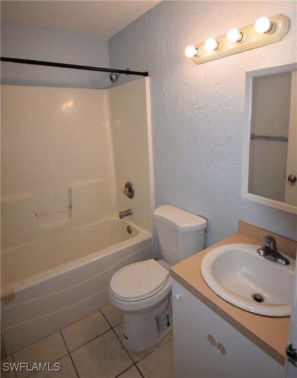 full bathroom featuring shower / tub combination, vanity, toilet, and tile patterned flooring