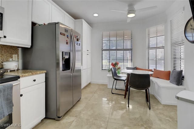 kitchen featuring backsplash, ceiling fan, white cabinets, and stainless steel appliances