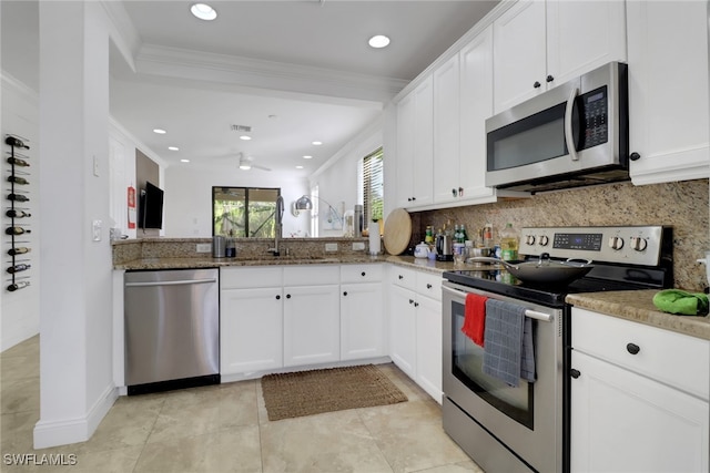 kitchen featuring decorative backsplash, ornamental molding, stainless steel appliances, sink, and white cabinetry