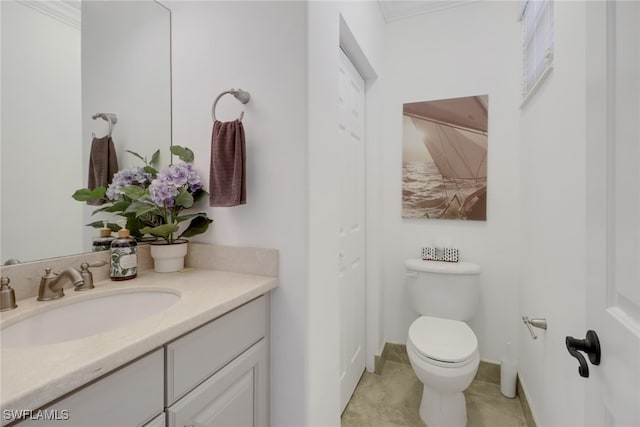 bathroom featuring toilet, vanity, and ornamental molding