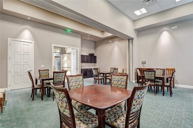 dining space featuring a paneled ceiling and light carpet