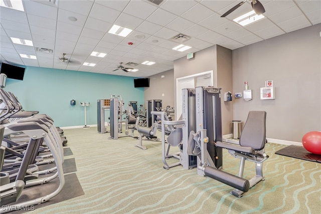 workout area with carpet flooring, ceiling fan, and a paneled ceiling